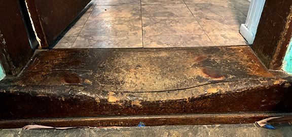worn wooden step between the living room and the kitchen