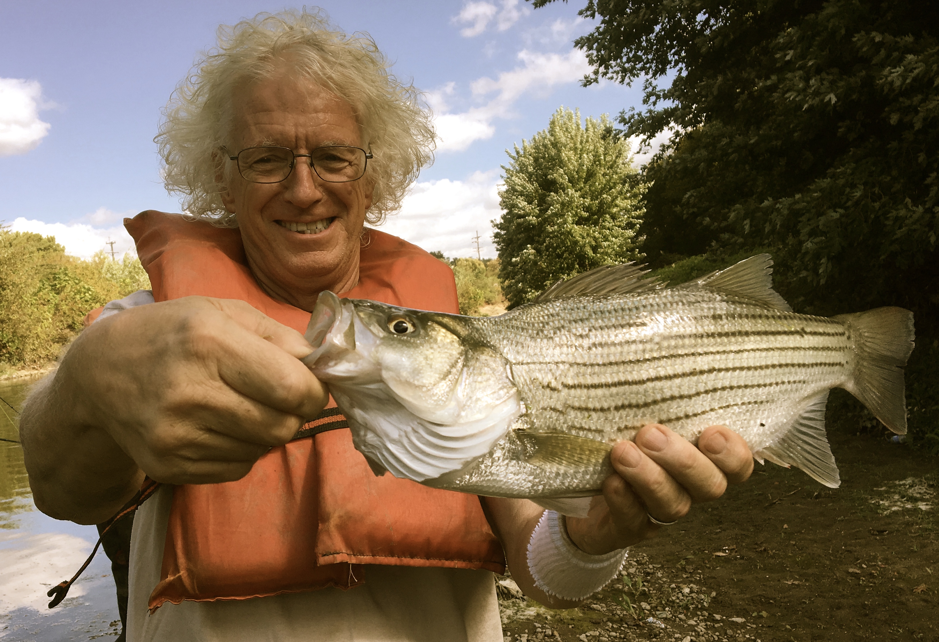 Bruce Koehler holding a striped bass caught in the Mill Creek